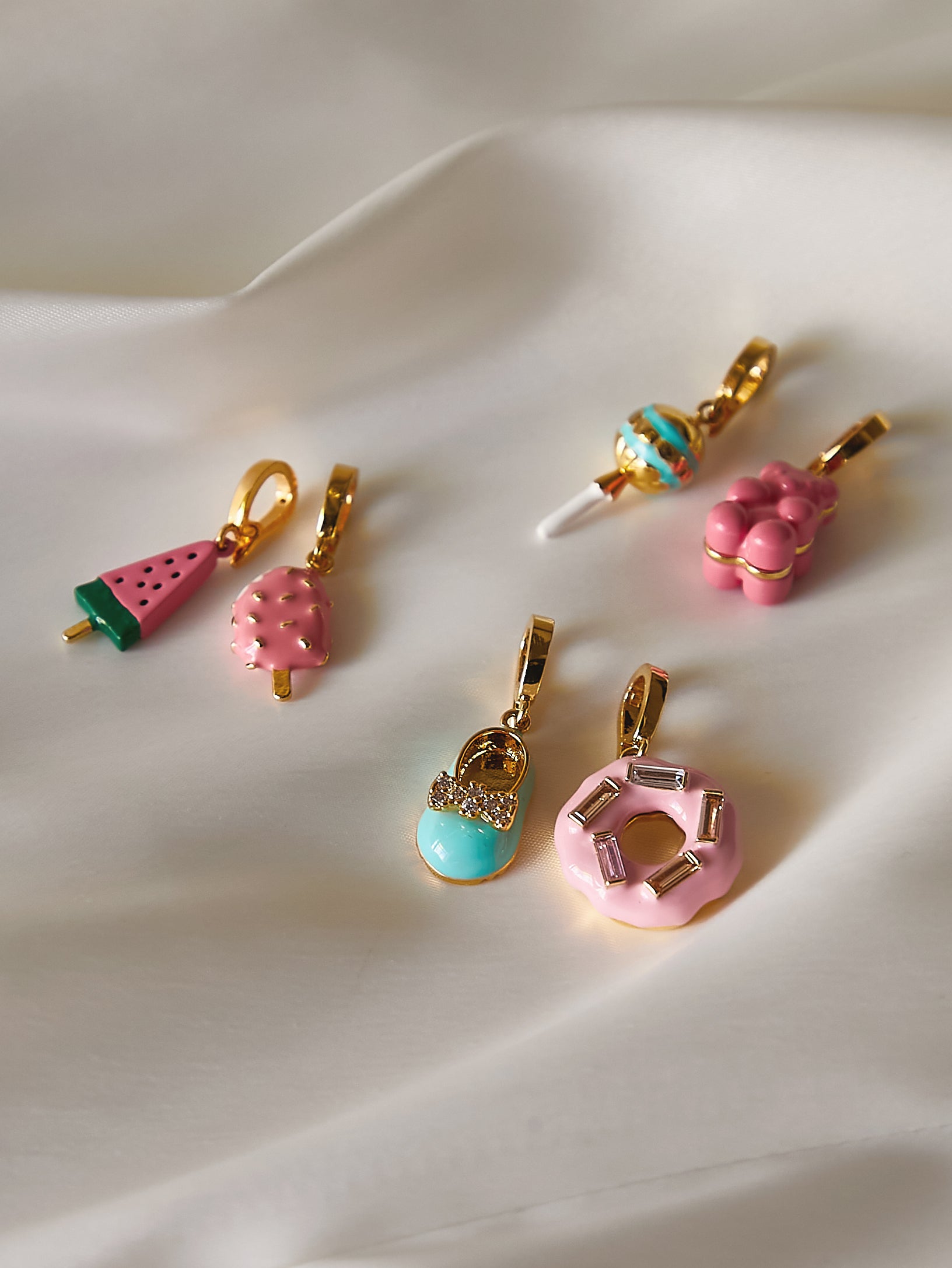 Colorful Jyuls By Yu snap on & off charms on a white fabric background